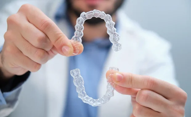 unrecognizable-orthodontist-holding-trainer-dental-01 unrecognizable-orthodontist-holding-trainer-dental-01